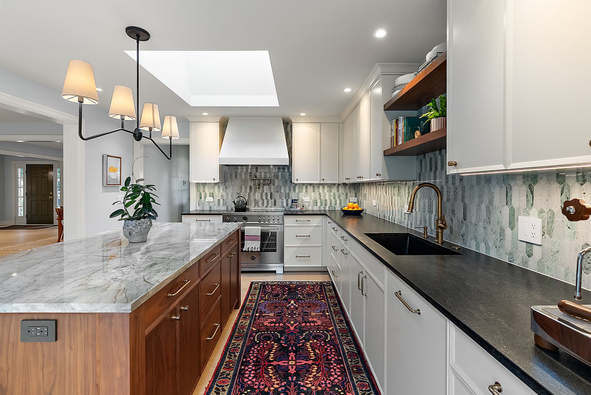 Custom kitchen by Stile Cabinetry with white inset cabinetry and a walnut island